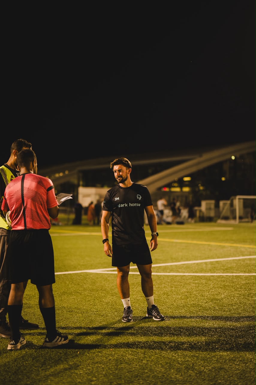 Jason speaking with another coach on the pitch